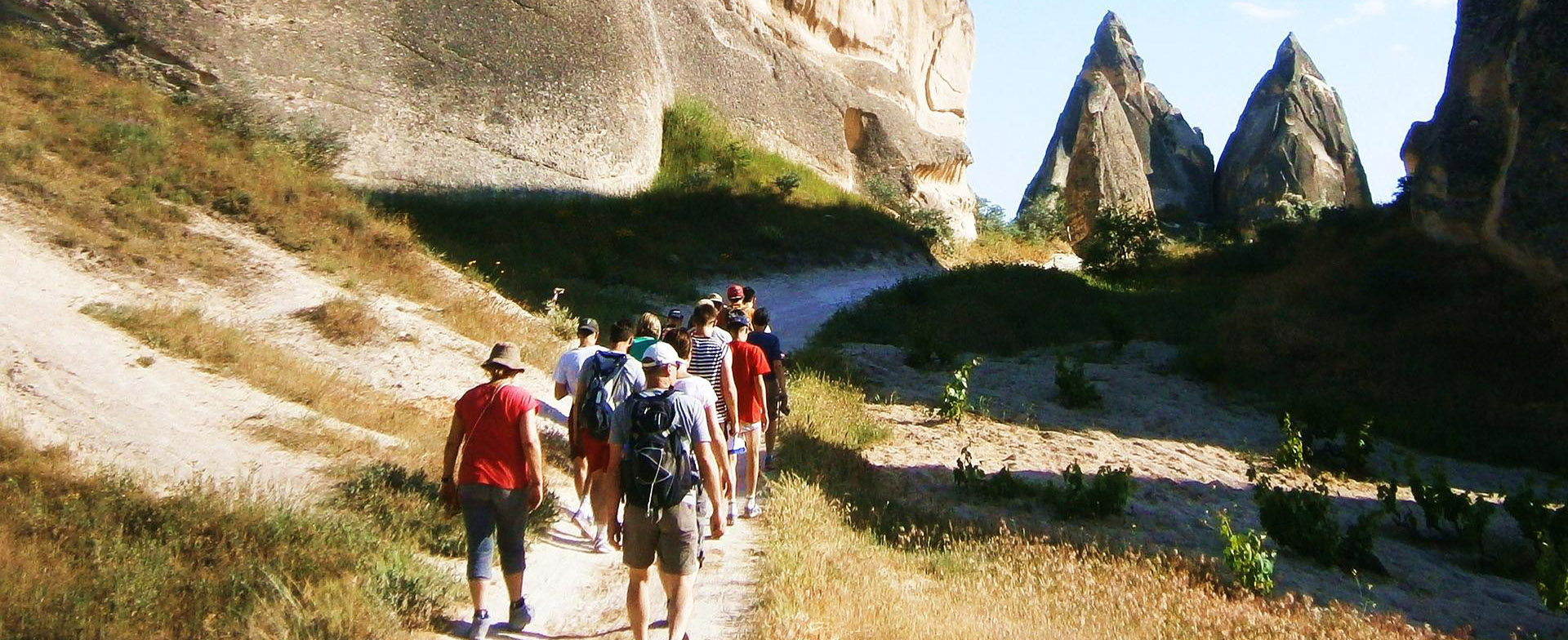 A group of hikers on a trail through Cappadocia valleys