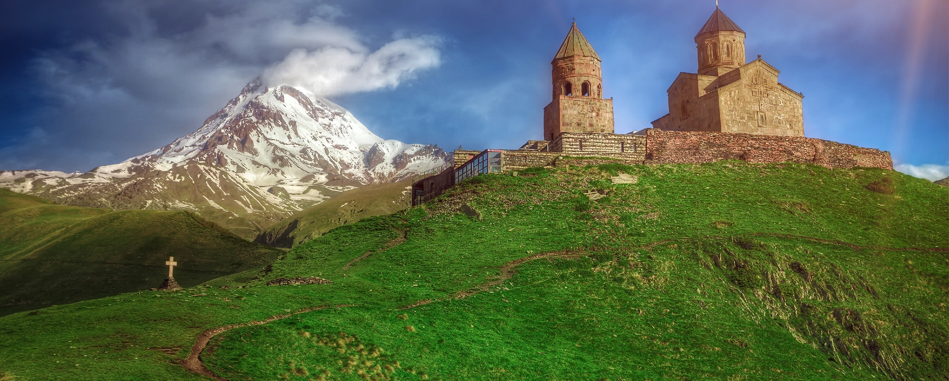 Gergeti Trinity Church with a snowy Caucasus peak behind it
