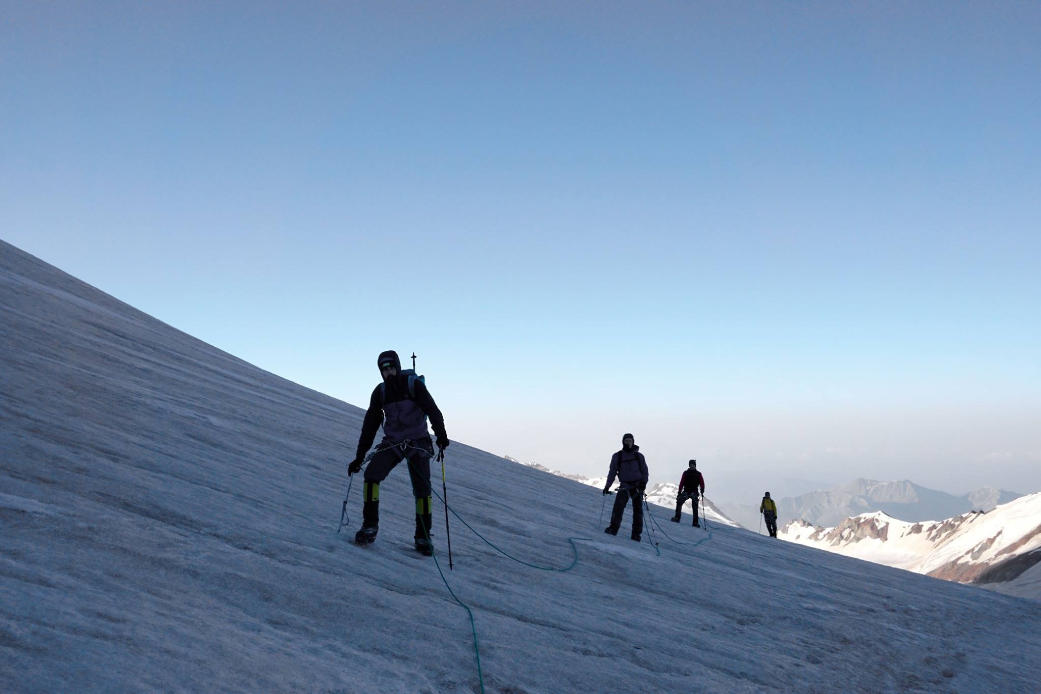 A roped team ascending a snowy slope near Mount Kazbek