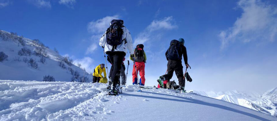 Ski tourers climbing a snowy slope in the Caucasus