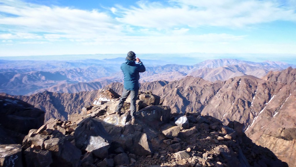 A hiker looking across the High Atlas from Mount Toubkal